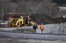 Workers walk on the rail track in Lac-Megantic