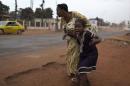 A mother holds her child while attempting to take cover as repeated gun shots are heard close to Miskine district during continuing sectarian violence in the capital Bangui