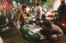 Emergency rescue workers and concert spectators tend to injured victims from an explosion during a music concert at the Formosa Water Park in New Taipei City, Taiwan, Saturday, June 27, 2015. The New Taipei City fire department says 200 people were injured in an accidental explosion of colored theatrical powder Saturday night near a performance stage where about 1,000 people were gathered for party. (AP Photo) TAIWAN OUT