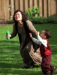 FILE - In this May 25, 1997 file photo, Phan Thi Kim Phuc plays with her son, Thomas Huy Hoang, 3, at a friend's home in Toronto. As a terrified nine-year-old, Phuc was photographed running down a South Vietnamese road after a June 8, 1972 napalm attack. Now a permanent resident in Canada, the 33-year-old says "even though I suffered physically and emotionally, I'm happy, because I'm living without hatred." (AP Photo/Nick Ut)