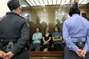 Feminist punk group Pussy Riot members, from left, Yekaterina Samutsevich, Maria Alekhina and Nadezhda Tolokonnikova sit in a glass cage at a court room in Moscow, Russia on Friday, Aug 17, 2012. The women, two of whom have young children, are charged with hooliganism connected to religious hatred but the case is widely seen as a warning that authorities will only tolerate opposition under tightly controlled conditions. T-shirt on right worn by Tolokonnikova is Spanish and translates to "They shall not pass", a slogan often used to express determination to defend a position against an enemy. (AP Photo/Mikhail Metzel)