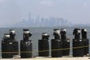 Mortars placed on a barge docked in the Staten Island borough of New York are in front of the hazy lower Manhattan skyline, Saturday, June 29, 2013. Forty thousand shells are being loaded onto four barges in preparation for the Macy's Fourth of July fireworks display. (AP Photo/Mary Altaffer)