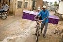A man pushes his bicycle to deliver a coffin in the Bujumbura suburb of Kanyosha on January 10, 2016