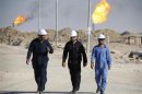 Iraqi workers walk in West Qurna oilfield in Iraq's southern province of Basra