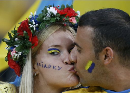 Fans of Ukraine kiss before their Group D Euro 2012 soccer match against England at Donbass Arena in Donetsk