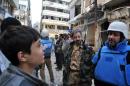 United Nations workers talk with rebel fighters in the besieged district of Homs, on February 8, 2014