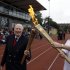 The Olympic Flame is passed between Sir Roger Bannister and Oxford doctoral student Nicola Byrom on the running track at Iffley Road Stadium in Oxford, England, Tuesday July 10, 2012. Bannister was the first person ever to run a sub four-minute-mile, on May 6, 1954, at this track in Oxford. Bannister returned to the site of his greatest sporting achievement, to participate in the Olympic Torch relay as the Olympic flame is carried around the country to the opening ceremony of the 2012 London Olympic Games. (AP Photo/Lefteris Pitarakis)