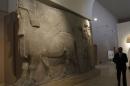 Man walks past human-headed winged bull statues from Khorsabad, at the Iraqi National Museum in Baghdad