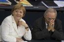 German Chancellor Merkel and Finance Minister Schaeuble talk during a debate about the EU fiscal pact at Bundestag in Berlin