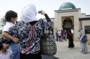 A woman takes a picture of the Islamic Center of Murfreesboro after midday prayers on Friday, Aug. 10, 2012, in Murfreesboro, Tenn. Opponents of the mosque waged a two-year court battle trying to keep it from opening. (AP Photo/Mark Humphrey)