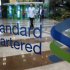 File photo of workers at Standard Chartered Bank walking in the lobby of its headquarters in Seoul