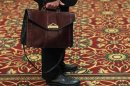 A man holds his briefcase while waiting in line during a job fair in Melville, New York