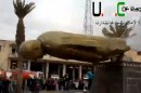 In this Monday, March 4, 2013 image taken from video obtained from Ugarit News, which has been authenticated based on its contents and other AP reporting, a statue of former Syrian President Hafez Assad falls in a central square in Raqqa, Syria. Syrian rebels pushed government troops from most of the northern city of Raqqa Monday, setting off celebrations in a central square where scores of cheering protesters tore down a bronze statue of President Bashar Assad's late father and predecessor, activists said. (AP Photo/Ugarit News via AP video)