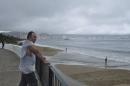 Man looks at the sea as dark clouds brought by Tropical storm Trudy are seen in Acapulco