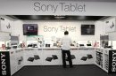 An employee adjusts Sony Tablets displayed at an electronics store in Tokyo