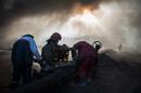 Workers tasked with putting out the fire in an oil well assemble a water pipeline in the town of Qayyarah, some 70 km south of Mosul on November 20, 2016
