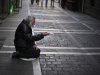A man begs for alms in a street, in Pamplona, northern Spain, Tuesday, Oct. 30, 2012. Spain's National Statistics Institute says Tuesday that the country's economy contracted 0.3 percent in the third quarter from the previous three month period. Spain is in a double-dip recession and has a 25 percent unemployment rate. Prime Minister Mariano Rajoy said Monday the country has no immediate need to ask for outside aid to help deal with its debts. (AP Photo/Alvaro Barrientos)