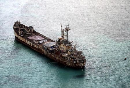 Filipino soldiers wave from the dilapidated Sierra Madre ship of the Philippine Navy as it is anchored near Ayungin shoal in the Spratly