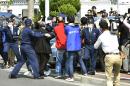 Media crowds the vehicle which carries Yasuo Yamamoto, who admitted to landing a drone on the roof of the prime minister's office, in front of Obama Police Station in Obama, Fukui prefecture, western Japan Saturday, April 25, 2015. Japanese police arrested the man, officials said Saturday. Tokyo metropolitan police said the man turned himself in late Friday in Fukui police in western Japan. (Yohei Fukai/Kyodo News via AP) JAPAN OUT, MANDATORY CREDIT