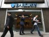 People walk past a branch of Barclays Bank in the City of London