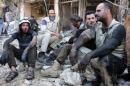 Syrian civil defence volunteers rest following a reported airstrike on April 23, 2016 in the rebel-held neighbourhood of Tareeq al-Bab in the northern city of Aleppo