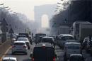 Rush hour traffic fills an avenue leading up to the Arc de Triomphe which seen through a small-particle haze at Neuilly-sur-Seine, Western Paris
