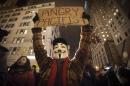 A demonstrator wearing a Guy Fawkes mask walks up 6th Ave as he protests against the police in Manhattan