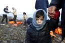 A Syrian refugee child looks on, moments after arriving on a raft with other Syrian refugees on a beach on the Greek island of Lesbos