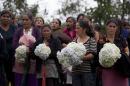 Neighbors hold bouquets of Hydrangeas during the burial service of Gilberto Francisco Ramos Juarez, a Guatemalan boy whose decomposed body was found in the Rio Grande Valley of South Texas, in San Jose Las Flores, Guatemala, Saturday, July 12, 2014. The 15-year-old Guatemalan migrant was buried in his hometown Saturday, nearly a month after he became a symbol of the perils facing unaccompanied children who have been flooding illegally into the U.S. (AP Photo/Moises Castillo)