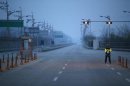 A South Korean police officer stands guard on an empty load connecting the Kaesong Industrial Complex (KIC) inside the North Korean border with the South's CIQ in Paju