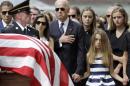 FILE - In this June 6, 2015 file photo, Vice President Joe Biden, accompanied by his family, holds his hand over his heart as he watches an honor guard carry a casket containing the remains of his son, former Delaware Attorney General Beau Biden, into St. Anthony of Padua Roman Catholic Church in Wilmington, Del. for funeral services. Biden faces the daunting decision of how and when to re-enter public life after burying his 46-year-old son. On Wednesday, Biden returns to Washington for lunch with the president and a meeting with the Ukrainian leader, but he'll head straight back to Wilmington, evoking memories of the nightly trips home that Biden took after he lost his first child decades ago at the start of his political careerStanding alongside the vice president are Beau's widow Hallie Biden, left, and daughter, Natalie. Beau Biden died of brain cancer May 30 at age 46. (AP Photo/Patrick Semansky)