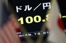 A monitor displaying Japanese yen's exchange rate against U.S. dollar is seen between U.S. and Japanese national flags in Tokyo