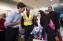FILE - In this Dec. 11, 2015 file photo, Prime Minister Justin Trudeau, left, greets Georgina Zires, center, Madeleine Jamkossian, second right, and her father Kevork Jamkossian, refugees fleeing from Syria, as they arrive at Pearson International airport, in Toronto. Trudeau has a message for refugees rejected by U.S. President Donald Trump: Canada will take you. He also intends to talk to Trump about the success of Canada's refugee policy. Trudeau reacted to Trump's ban of Muslims from certain countries by tweeting Saturday: 
