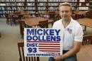 Mickey Dollens poses for a photo with one of his campaign signs in the library at U.S. Grant High School, where he used to teach English, in Oklahoma City, Wednesday, June 29, 2016. Dollens said he decided to run for the state House in Oklahoma to fix what he saw as problems the GOP-controlled Legislature was inflicting on education. Then the 28-year-old got laid off as a result of state-imposed cuts to public schools. Dollens won his Democratic primary with more than 90 percent of the vote and now advances to face a Republican in November. (AP Photo/Sue Ogrocki)