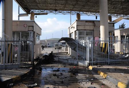 A man walks past a damaged gate after an explosion at Cilvegozu border gate on the Turkish-Syrian border in Hatay province February 11, 2013, in this picture taken by Anadolu Agency. REUTERS/Cem Genco/Anadolu Agency