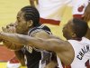 Miami Heat point guard Mario Chalmers (15) fouls San Antonio Spurs small forward Kawhi Leonard (2) during the first half of Game 2 of the NBA Finals basketball game, Sunday, June 9, 2013 in Miami. (AP Photo/Wilfredo Lee)
