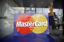 File photo of an employee standing behind a MasterCard logo during the launch of the international credit card issuer's first ATM transaction in Myanmar, in Yangon