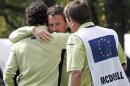 Team Europe golfer McDowell hugs McIlroy after them won their match against U.S. golfers Furyk and Snedeker on the on the 18th green during the morning foursomes round at the 39th Ryder Cup matches at the Medinah Country Club