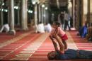 FILE - In this Friday, June 5, 2015, file photo, a father plays with his daughter after Friday afternoon prayers in Al-Azhar Mosque in the Islamic Cairo neighborhood, in Cairo, Egypt. (AP Photo/Mosa'ab Elshamy, File)
