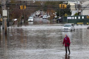 A woman walks through a flooded street in Staten Island. (Reuters)