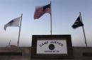 Flags wave above the sign posted at the entrance to Camp Justice at Guantanamo Bay U.S. Naval Base