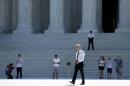 A police officer patrols the plaza in front of the U.S. Supreme Court building in Washington