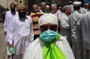 A Muslim pilgrim wears a surgical mask