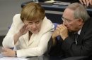 German Chancellor Merkel talks with her Finance Minister Wolfgang Schaeuble before the vote for ratification of the European Union fiscal pact in the Reichstag, the seat of the German lower house of parliament, the Bundestag, in Berlin