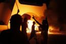 Demonstrators celebrate after burning a car as they stormed the headquarters of the Islamist Ansar al-Sharia militia group in Benghazi