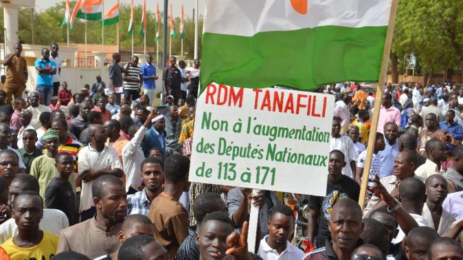 A boy hold a sign reading &quot;No to the increase of number of the members of parlament from 113 to 171&quot; during a demonstration in Niamey against president Mahamadou Issoufou&#39;s regime on June 6, 2015