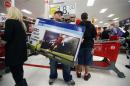 Holiday shopper carries a discounted television to the checkout at the Target retail store in Chicago