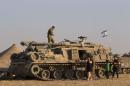 An Israeli soldier stands on top of a military vehicle in a base near Sa'ad in the southern district of Israel