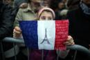 A child holds-up a hand drawn French flag as people gather on November 14, 2015 in Turin, a day after deadly attacks in Paris