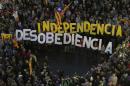 People gather with banners that read "Independence" and "disobedience" during a protest outside Barcelona's City Council on October 13, 2015